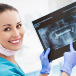 A dentist holding an x-ray of teeth